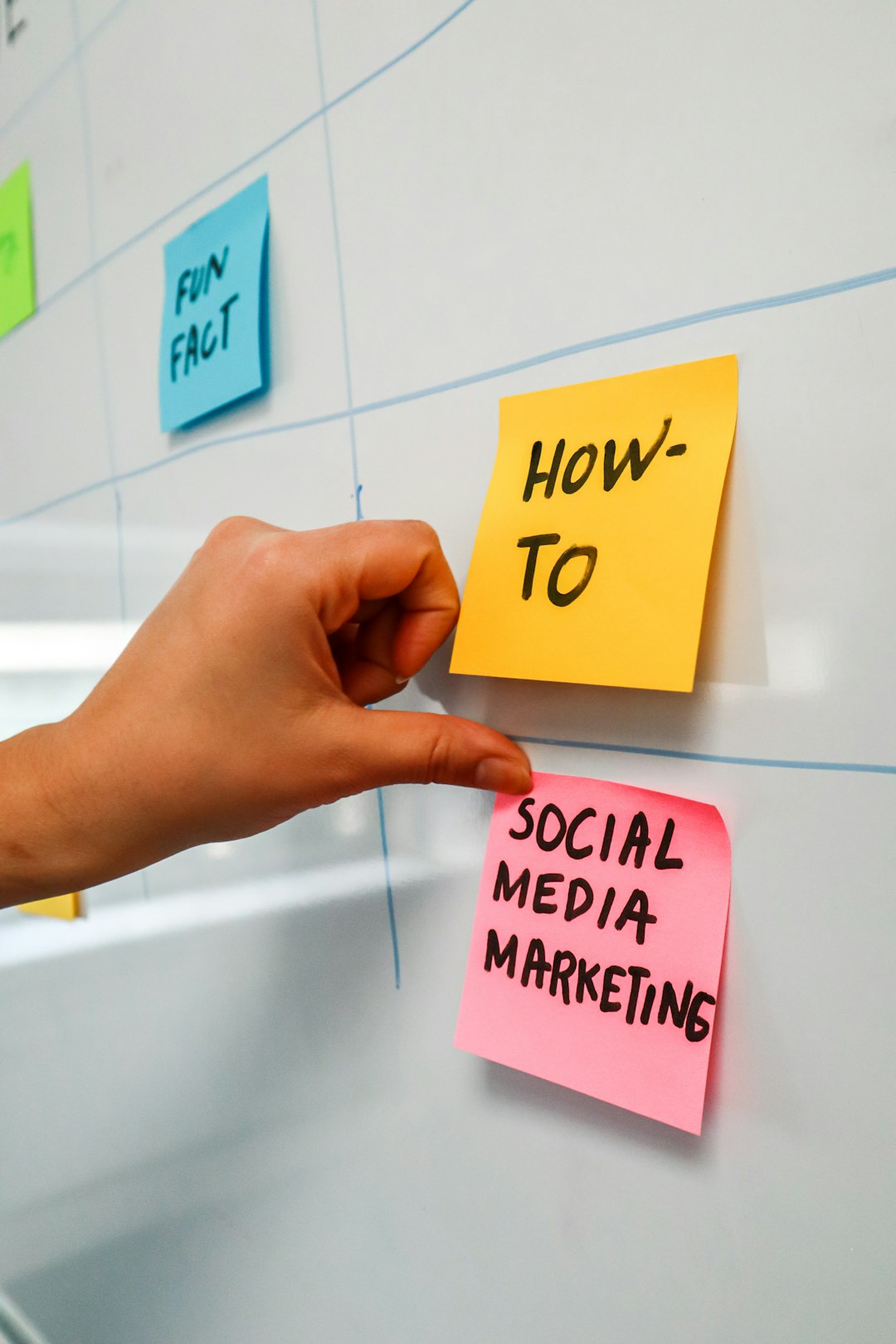 why-choose-us Person sticking a post-it on a white board with the words Social Media Marketing written on it